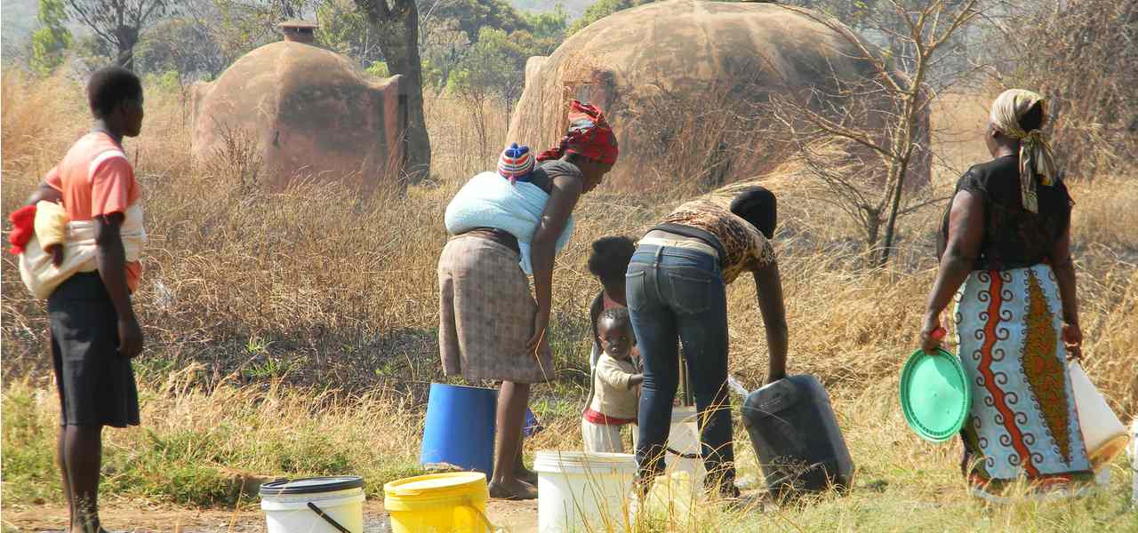 A family collects water from a single tap amidst the cholera outbreak in Zimbabwe, 2009
